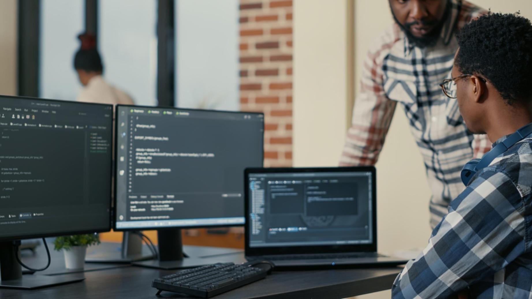 Estudiante trabajando en diseño 3D con múltiples monitores